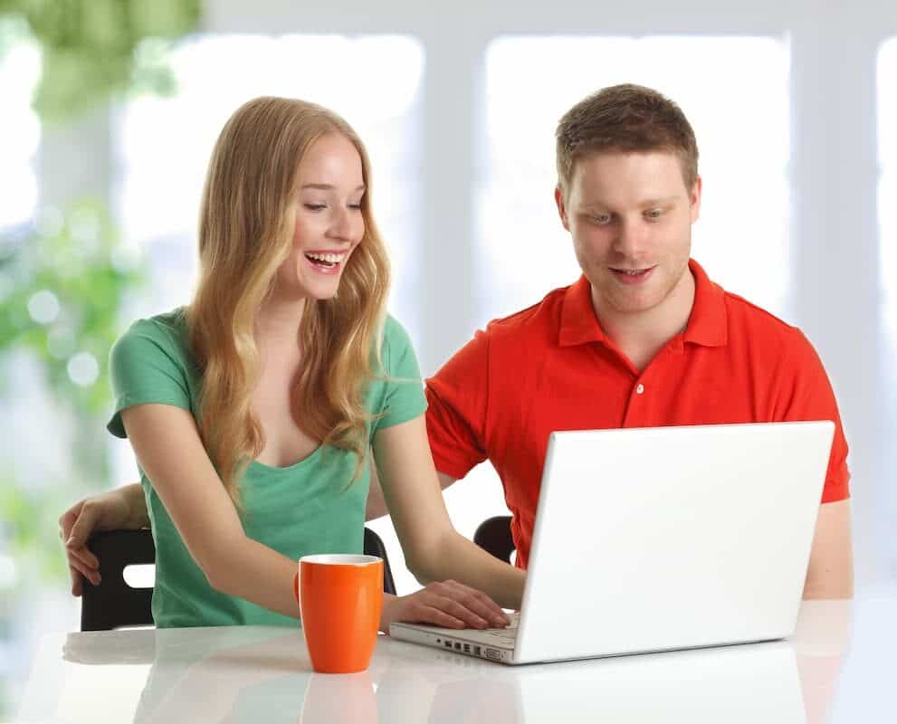 Couple looking at laptop  searching Where To Enjoy employee and member benefits